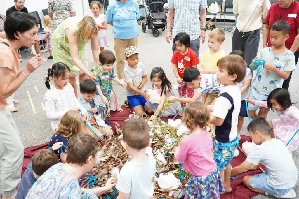 Children and adults surrounding nature elements and touching them.